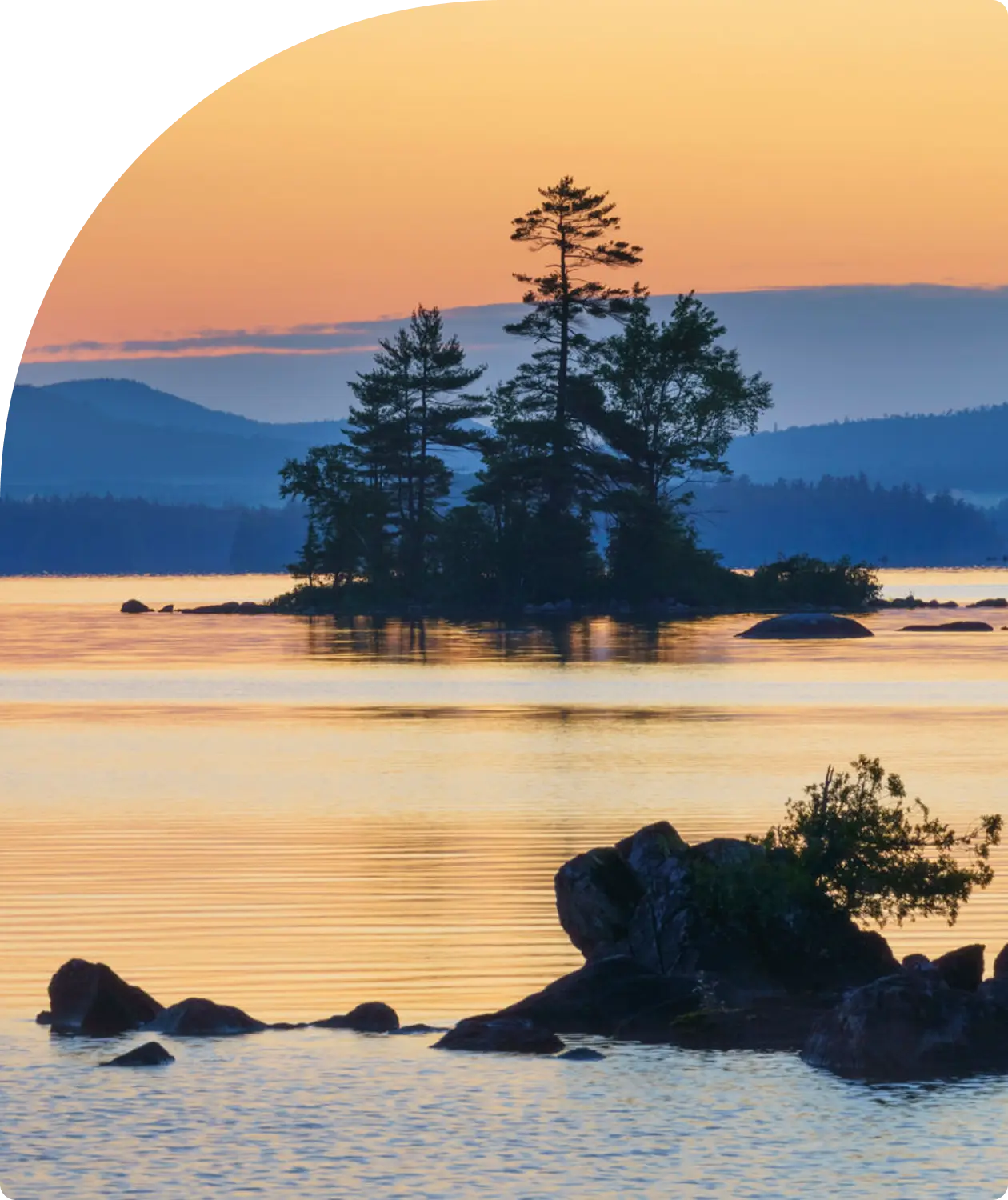 Sunset over lake with silhouetted trees