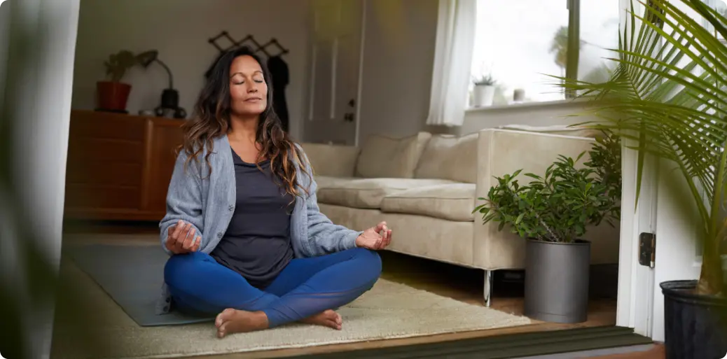 Woman meditating in peaceful living room